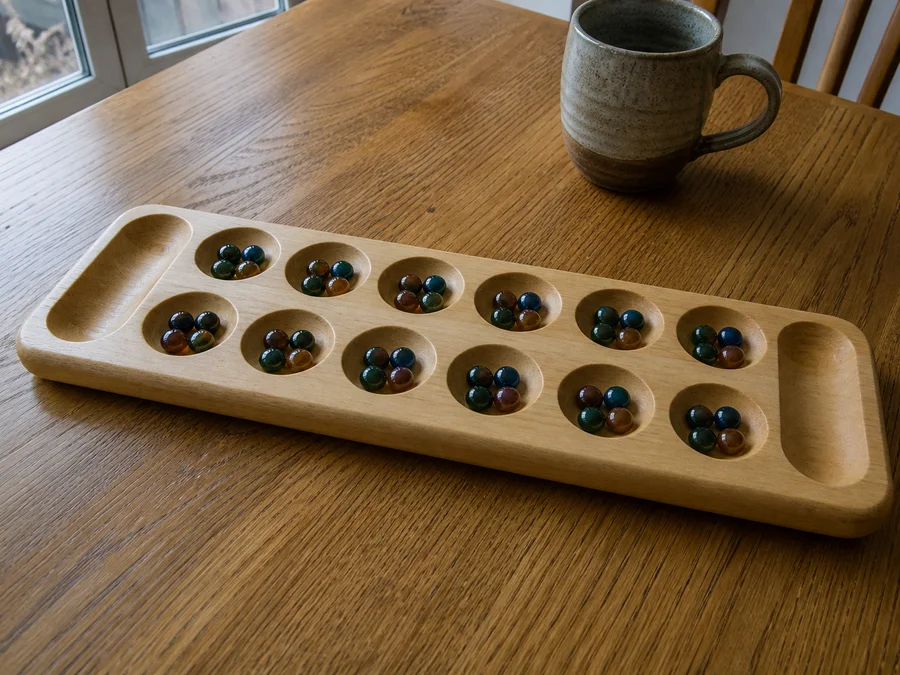 Kalah mancala opening: six pits a side with four seeds each, South on the near row
